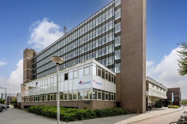 Zakelijk kantoorpand aan de Jan Tooropstraat in Amsterdam met gevels van glas en baksteen en het logo van Atalmedial op de voorgevel.